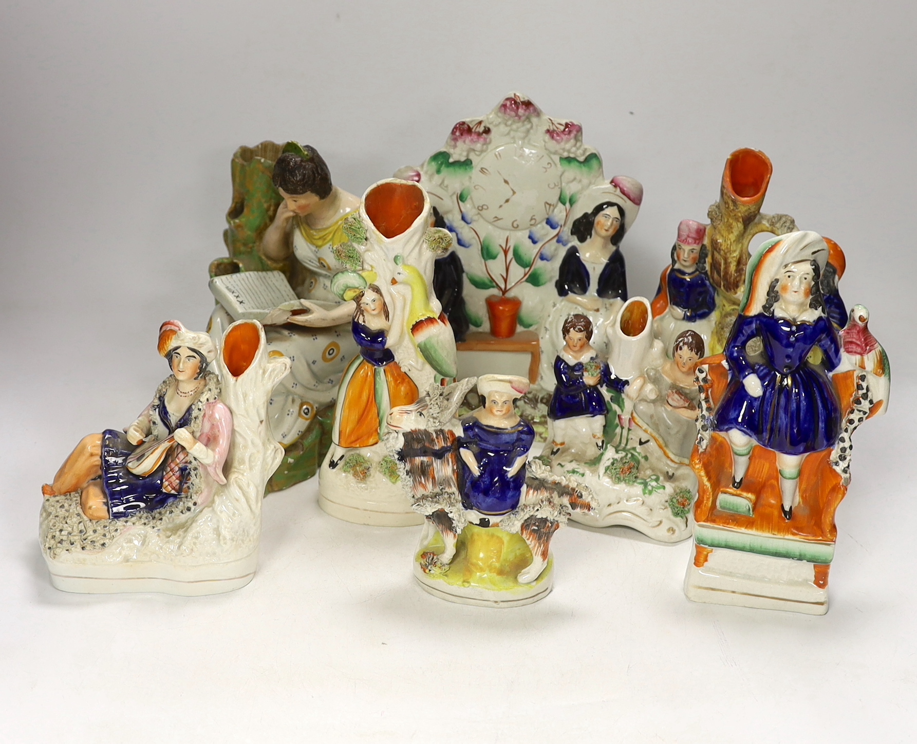An early 19th century Staffordshire pearlware figure of a seated lady and seven mid 19th century Staffordshire pottery figures